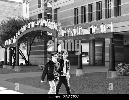 Zwei junge Männer asiatischer Abstammung lachen vor dem Henry Koffler Gebäude mit den Skulpturen der Wissenschaftler an der Universität von Arizona, Tucson, AZ Stockfoto