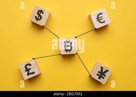 Bitcoin Kryptowährung Konzept und Währung Zeichen - abstrakte Zeichen auf Holzwürfeln mit gelbem Hintergrund. Nahaufnahme. Stockfoto