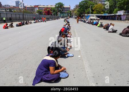 Kathmandu, Nepal. April 2020. Tägliche Wettarbeiter warten darauf, dass im Buspark Lebensmittel verteilt werden, während der landesweiten Lockdown, die nach dem Corona-Virus (COVID-19) in Kathmandu, Nepal, am 20. April 2020 verhängt wurde. (Foto von Subash Shrestha/Pacific Press) Quelle: Pacific Press Agency/Alamy Live News Stockfoto