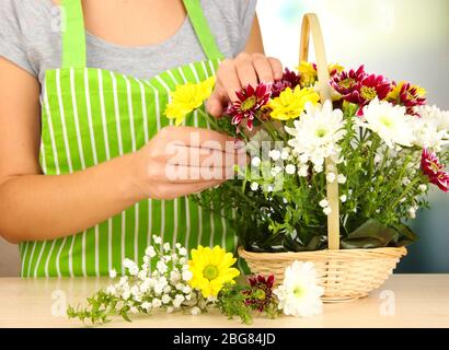 Florist macht Blumen Bouquet in Korbkorb Stockfoto