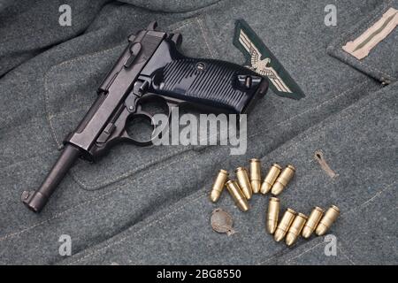 WWII Ära nazi deutsche Armee 9 mm halbautomatische Pistole mit Munition auf Armee grau einheitlichen Hintergrund Stockfoto