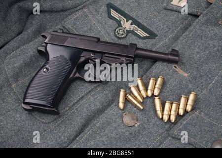 WWII Ära nazi deutsche Armee 9 mm halbautomatische Pistole mit Munition auf Armee grau einheitlichen Hintergrund Stockfoto