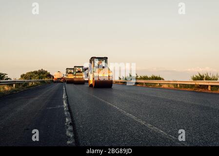 Straßenwalze Auftragen einer neuen Asphaltfläche. Asphalt ebnet Baustelle auf einer Autobahn Stockfoto