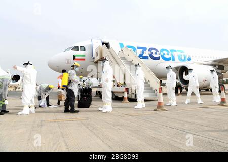 (200420) -- GOUVERNEMENT FARWANIYA (KUWAIT), 20. April 2020 (Xinhua) -- Medizinische Arbeiter desinfizieren Besatzungsmitglieder eines Flugzeugs am Kuwait International Airport in Farwaniya Governorate, Kuwait, am 20. April 2020. Am Kuwait International Airport begrüßen viele Kuwaitis, die aus dem Ausland zurückkehren, ihre Familien mit Ellbogen oder fliegenden Küssen, anstatt die übliche Methode, Hände zu schütteln, um zu vermeiden, sich mit COVID-19 zu infizieren. (Xinhua) ZU DEM Feature: Kuwaitis aus Übersee kehren durch Evakuierungsflüge inmitten der COVID-19-Ausbreitung nach Hause zurück Stockfoto