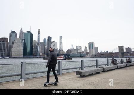 New York City, Usa. April 2020. Ein Skater trägt eine Gesichtsmaske als vorbeugende Maßnahme gegen die Ausbreitung des Coronavirus im Brooklyn Bridge Park.die Vereinigten Staaten haben 40,000 bestätigte Todesfälle durch Coronavirus übertroffen, wobei New York das Epizentrum der Krankheit ist. Quelle: SOPA Images Limited/Alamy Live News Stockfoto