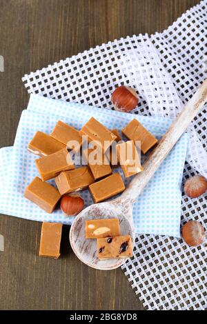 Viele Toffee in Holzlöffel auf Servietten auf Holztisch Stockfoto