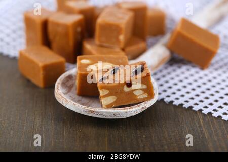 Viele Toffee in Holzlöffel auf Serviette auf Holztisch Stockfoto