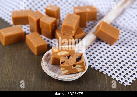 Viele Toffee in Holzlöffel auf Serviette auf Holztisch Stockfoto