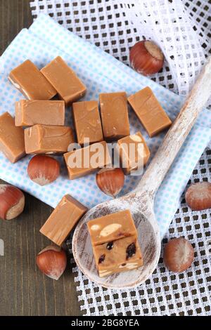 Viele Toffee in Holzlöffel auf Servietten auf Holztisch Stockfoto