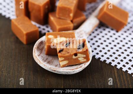 Viele Toffee in Holzlöffel auf Serviette auf Holztisch Stockfoto