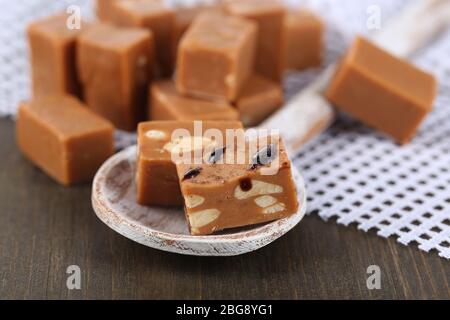 Viele Toffee in Holzlöffel auf Serviette auf Holztisch Stockfoto