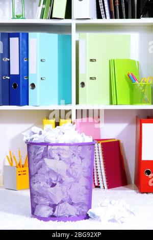 Papierkorb mit zerknittertem Papier gefüllt, auf dem Boden im Büroraum Stockfoto