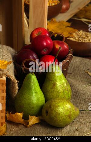 Äpfel im Korb und Birnen auf Sacktuch Nahaufnahme Stockfoto