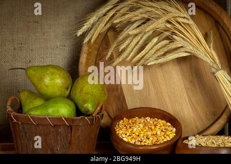 Birnen in Korb und Schalen von Körnern mit Holzwanne auf Regal auf Sacktuch Hintergrund Stockfoto