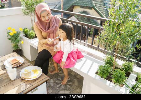 muslimische Frau und Kinder Frühstück zu Hause auf dem Dachgarten Stockfoto