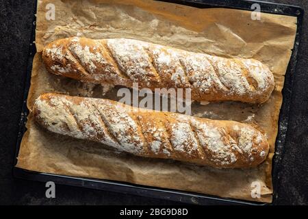 Zwei frische Vollkornbrot Baguettes auf Backpapier. Draufsicht. Stockfoto