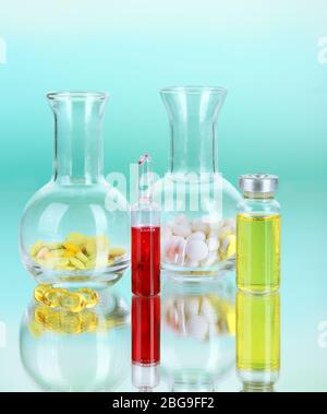 Medizinische Flaschen und Pillen auf grünem Hintergrund Stockfoto