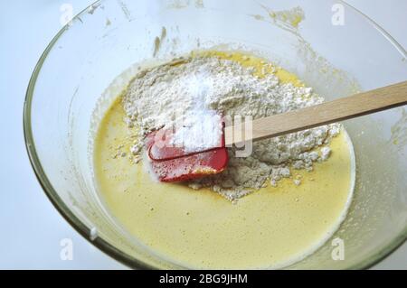 Rezept Reihenfolge der Fruchtschwamm Kuchen Backvorbereitung. Eier, Eigelb, Mehl und Obst zu einem flüssigen Teig mischen. Stockfoto