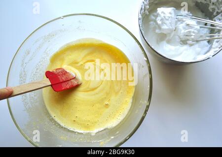 Rezept Reihenfolge der Fruchtschwamm Kuchen Backvorbereitung. Eier, Eigelb, Mehl und Obst zu einem flüssigen Teig mischen. Stockfoto