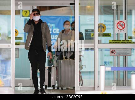 Vancouver, Kanada. April 2020. Reisende, die Gesichtsmasken tragen, werden in der Ankunftshalle des Vancouver International Airport in Richmond, Kanada, am 20. April 2020 gesehen. Kredit: Liang Sen/Xinhua/Alamy Live News Stockfoto