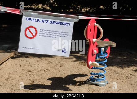 Berlin, Deutschland. April 2020. An einem Spielplatz in Charlottenburg sind Absperrbänder und ein Schild "Spielplatz gesperrt" angebracht. Aufgrund der Corona-Epidemie sind Spielplätze geschlossen. Es gibt ein Kontaktverbot für mehr als zwei Personen. Quelle: Jens Kalaene/dpa-Zentralbild/dpa/Alamy Live News Stockfoto