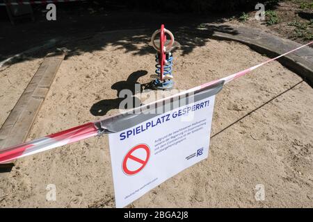 Berlin, Deutschland. April 2020. An einem Spielplatz in Charlottenburg sind Absperrbänder und ein Schild "Spielplatz gesperrt" angebracht. Aufgrund der Corona-Epidemie sind Spielplätze geschlossen. Es gibt ein Kontaktverbot für mehr als zwei Personen. Quelle: Jens Kalaene/dpa-Zentralbild/dpa/Alamy Live News Stockfoto