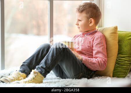 Niedlichen kleinen Jungen trinken heiße Schokolade zu Hause Stockfoto