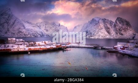 Das wunderschöne nordische Küstendorf reine, mit schneebedeckten Bergen, unberührtem Fjord und dramatischem Himmel. Stockfoto