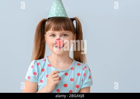 Kleines Mädchen feiert Geburtstag auf farbigen Hintergrund Stockfoto