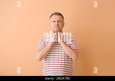 Reifen Mann Überprüfung Schilddrüse auf farbigen Hintergrund Stockfoto