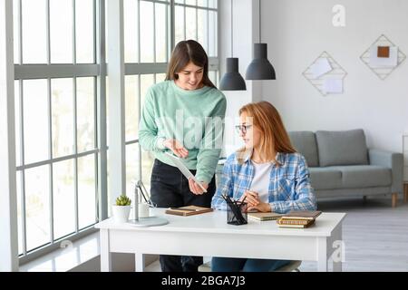 Frau hilft ihrer Mutter beim Online-Lernen zu Hause Stockfoto