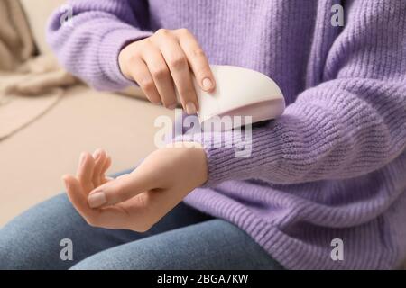 Frau, die zu Hause einen Stoffrasierer verwendet Stockfoto