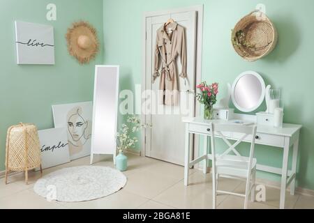 Interieur des Zimmers mit stilvollen Spiegeln und Frühlingsblumen Stockfoto