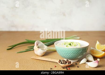 Leckere Joghurtsauce mit Gurke in Schüssel auf dem Tisch Stockfoto