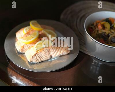 Frisch gekochter Lachs mit Zitronenscheibe auf einem Tisch, flaches DOF Stockfoto