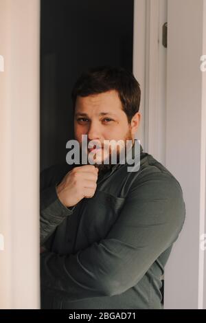 Porträt eines jungen kaukasischen Mannes, der in der Nähe der Tür steht. Stockfoto