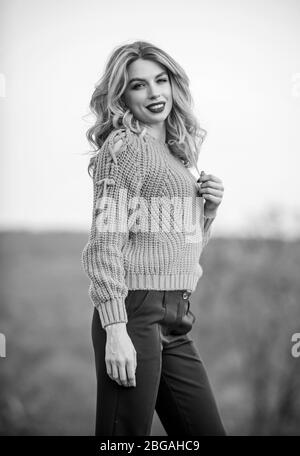 Wunderschöne Dame, die sich im Pullover aus Wolle gemütlich fühlt. Trendige Kleidung. Frau warmer Pullover Natur Hintergrund entschärft. Elegance Konzept. Schickes Mädchen Make-up Gesicht tragen Strickpullover. Stil ist ein Begriff des Gleichgewichts. Stockfoto