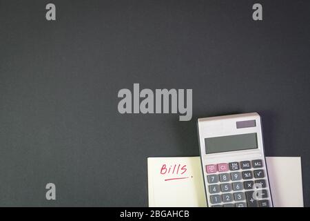 Rechnungen. Notizblock mit Rechner auf schwarzer Farbtabelle. Kopierbereich. Stockfoto