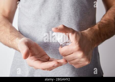 Ansicht des erwachsenen Mannes, der in der Spenderflasche Handdesinfektionsmittel verwendet Stockfoto