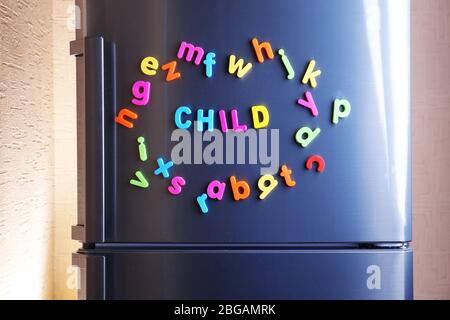 Word Child buchstabiert mit bunten magnetischen Buchstaben auf Kühlschrank Stockfoto