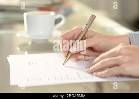 Nahaufnahme Seitenansicht der Frau Hand Ausfüllen Kontrollkästchen Formular auf einem Schreibtisch zu Hause Stockfoto