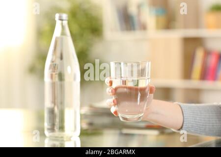 Nahaufnahme der Hände der Frau, die zu Hause ein Glas Mineralwasser halten Stockfoto