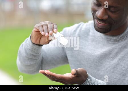 Nahaufnahme eines schwarzen Mannes, der in einem Park mit einem Händedesinfektionsmittel steht Stockfoto