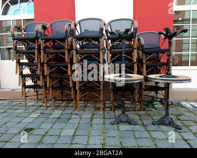 Gestapelte Stühle eines geschlossenen Restaurants im Freien. Stockfoto