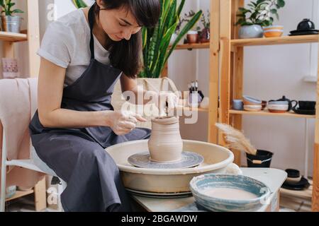 Fokussierte Person in eine Schöpfung von Tonvase eingetaucht Stockfoto