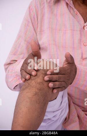 Alter Mann mit Knieschmerzen Stockfoto