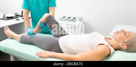 Traumatologe untersucht verletzten Bein einer Frau Patientin. Beinverletzungen Behandlung in einer modernen Klinik für Traumatologie Stockfoto