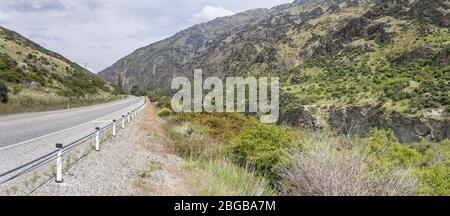 Landschaft mit Straße 6 und Kawarau River Schlucht Hängen, aufgenommen in hell bewölktem Frühlingslicht, Otago, South Island, Neuseeland Stockfoto