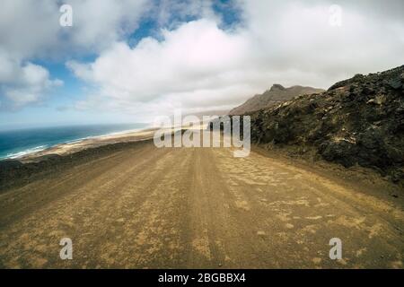 Off Road Bodenansicht gerader Weg und wilden Sandstrand am en im Hintergrund - Konzept des Abenteuers und alternative Natur rund um Lifestyle - Tourismus Stockfoto