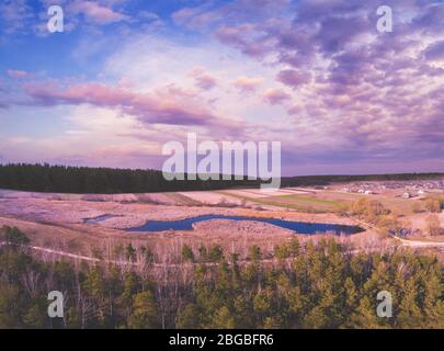 Frühling ländliche Landschaft am Abend mit schönen Himmel, Luftaufnahme. Panoramablick auf Dorf und See bei Sonnenuntergang. Panorama aus 9 Bildern Stockfoto